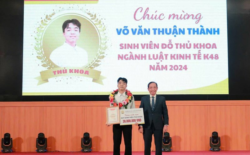 Associate Professor, Dr. Doan Duc Luong - Principal of Hue University of Law, awarded new student Vo Van Thuan Thanh - Valedictorian of K48. Photo: H. Huong.