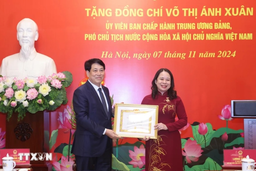President Luong Cuong presents the 30-year Party membership badge to Vice President Vo Thi Anh Xuan. Photo: Lam Khanh