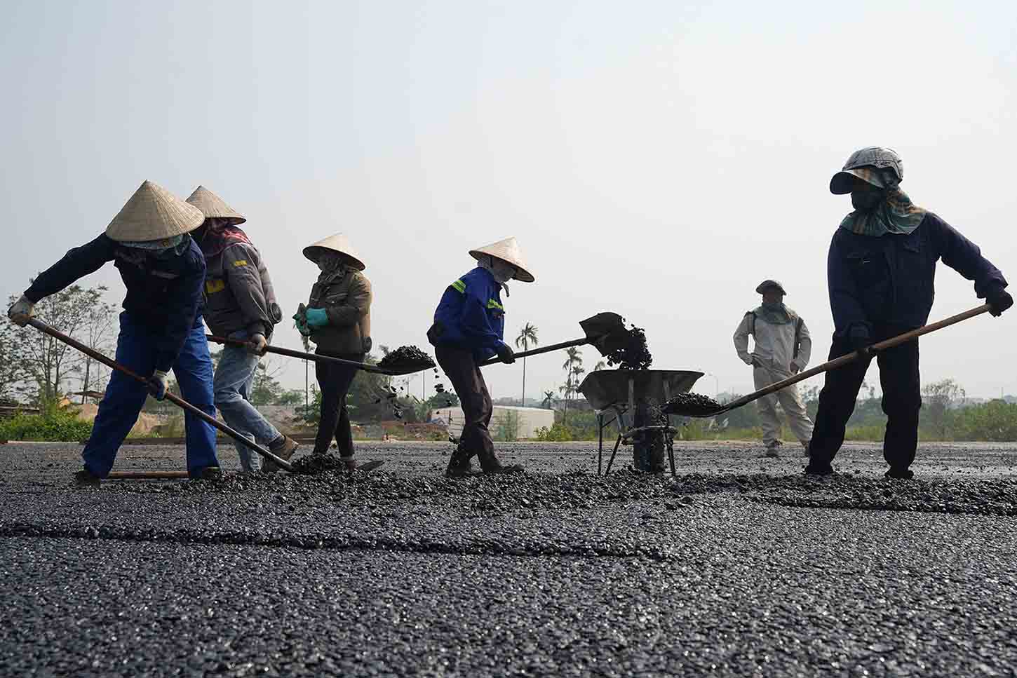 May moc, cong nhan duoc huy dong tham nhua mat duong. Anh: Huu Chanh