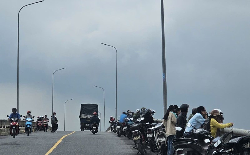 People standing on the bridge watching the search forces for the missing woman. Photo: H.Nguyen