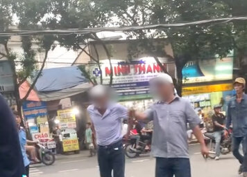 Mot nguoi dan ong cam dao, keo den ben canh tai xe taxi de de doa. Anh: Cat tu clip.