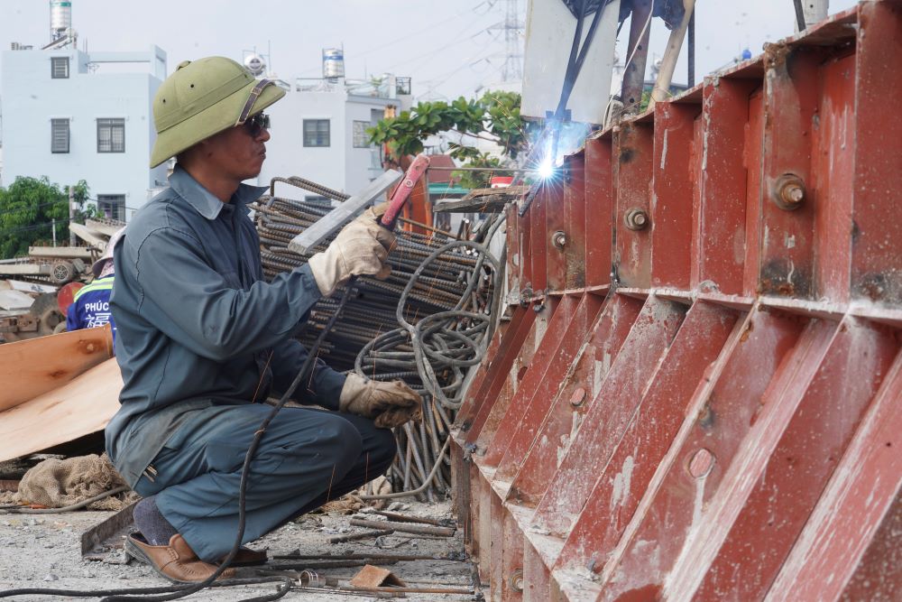   Theo ghi nhan cua phong vien Lao Dong, tren cong truong, hang chuc cong nhan cung thiet bi may moc dang khan truong hoan thien nhung hang muc con lai cua cau nhu thi cong ban mat cau, lap lan can va chuan bi tham nhua.