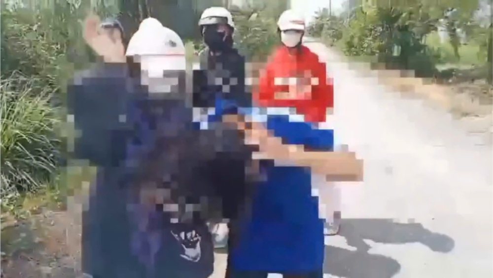 A group of female students beat up a friend on the street. Photo cut from video clip