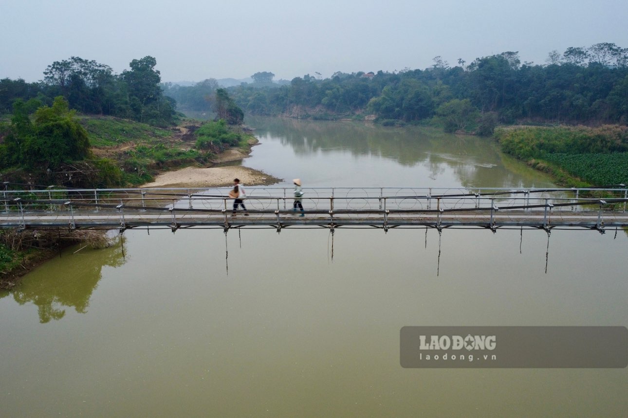 Người dân mình băng qua cầu treo bị đứt cáp. Ảnh: Việt Bắc,