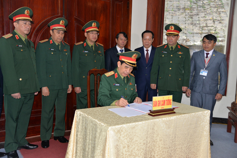 General Phan Van Giang writes his impressions in the memorial book at the relic site. Photo: Vu Tiep.