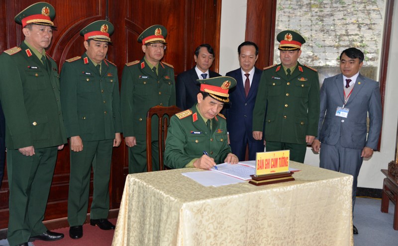 General Phan Van Giang writes his impressions in the memorial book at the relic site. Photo: Vu Tiep.