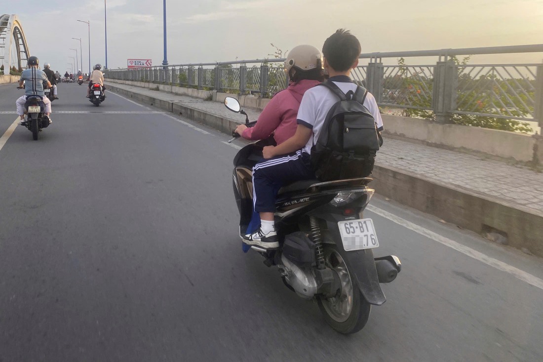 Phu huynh cho hoc sinh khong doi mu bao hiem di chuyen tu quan Ninh Kieu sang quan Cai Rang. Anh: Ta Quang