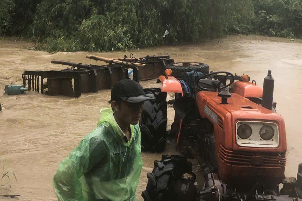 The scene of a car carrying 10 people overturned while crossing a stream, leaving one person missing in Phu Yen. Photo: Minh Hang