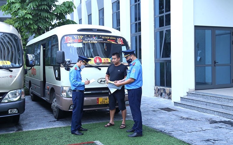 Inspectors of the Hanoi Department of Transport inspect contracted vehicles transporting students. Photo: Ninh Giang