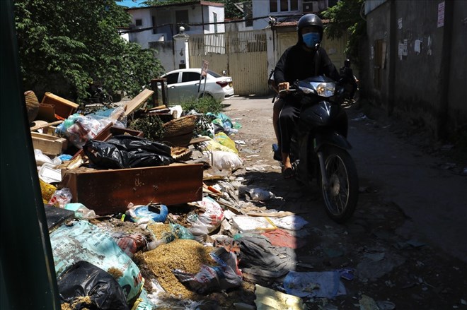 Garbage and solid waste occupy half the road, making it difficult for people to move around. Photo: Thu Hien
