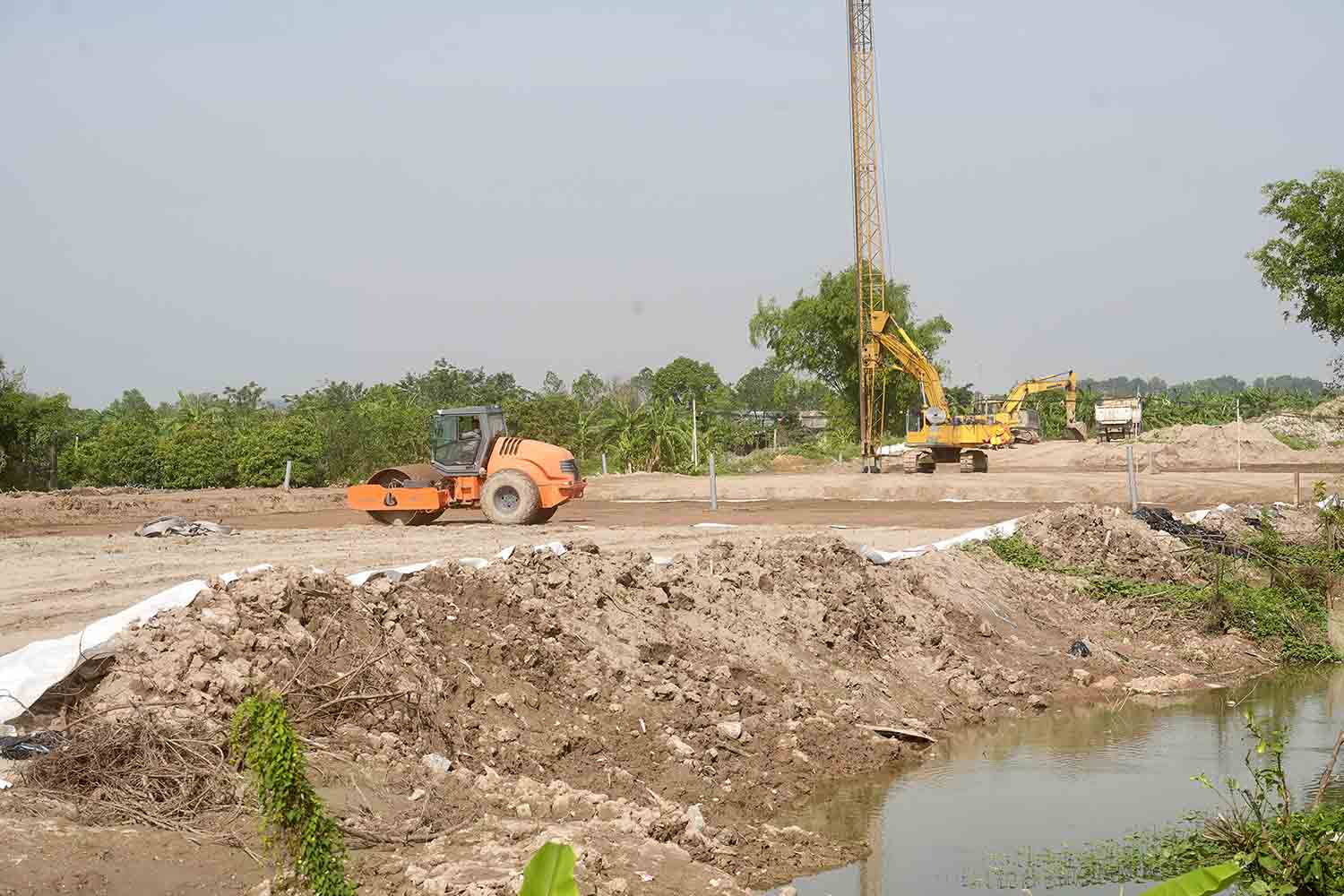 Tai day, nha thau dang trien khai thi cong hang muc xu ly nen dat yeu, chong tham. Anh: Huu Chanh