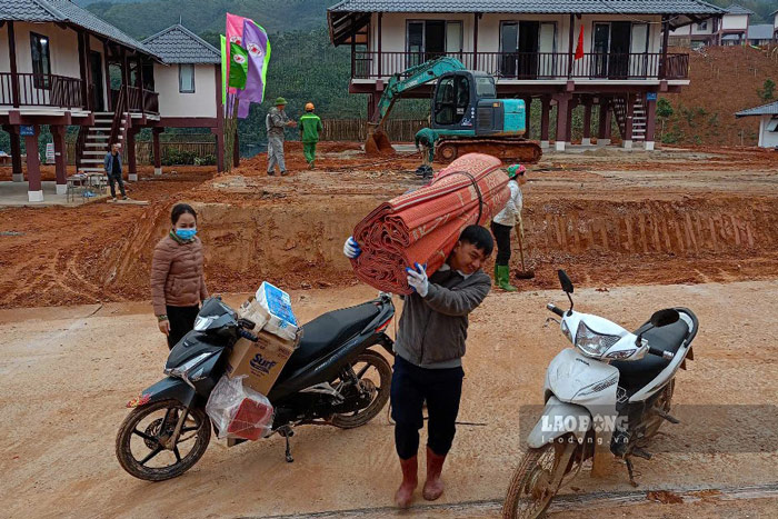 Villagers of Lang Nu move their belongings to new stilt houses in the resettlement area. Photo: Dinh Dai