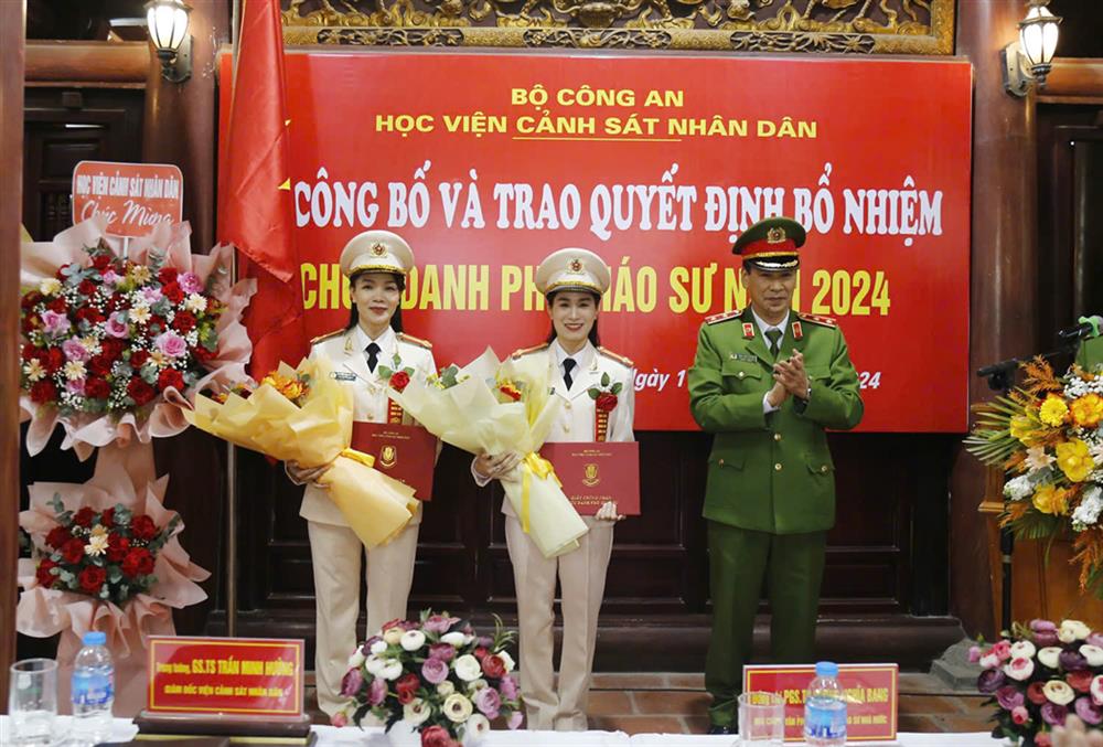 Lieutenant General, Professor, Dr. Tran Minh Huong - Chairman of the Council of Professors of Security Science awarded the appointment decision to 2 female Associate Professors. Photo: Ministry of Public Security