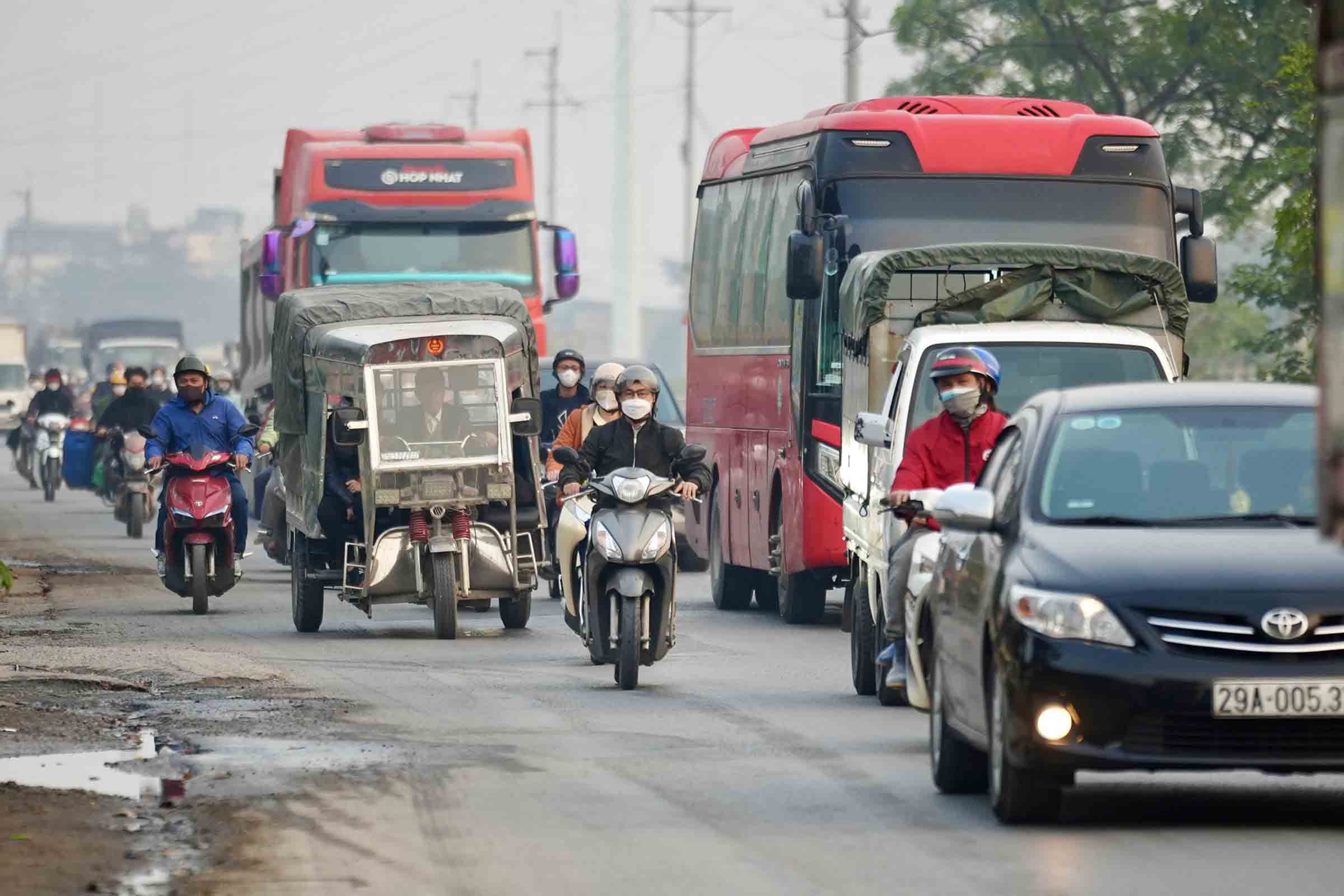 Oto tai, xe container noi duoi nhau chen lan cung nhieu xe may tren duong tinh 70, chieu giua thang 12. Anh: Huu Chanh