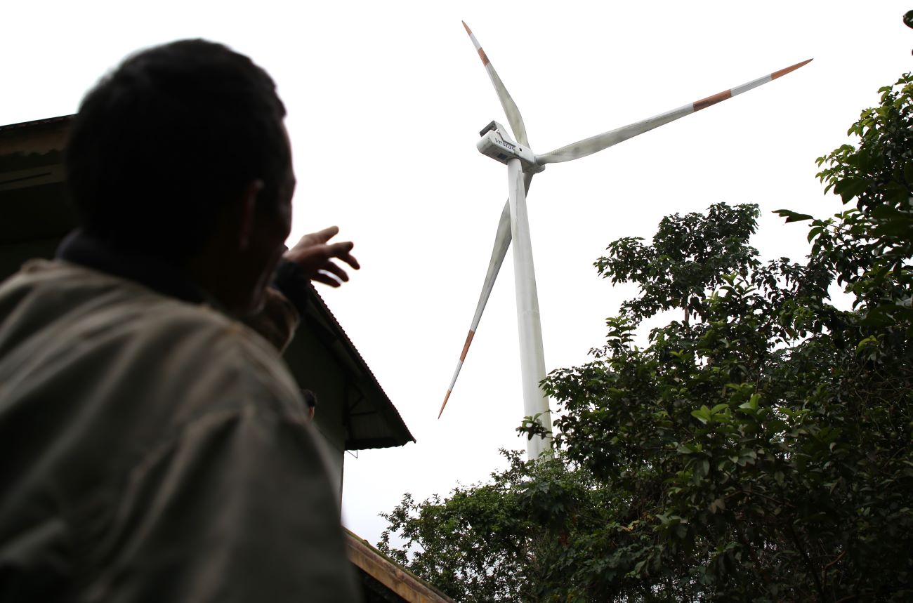 Trụ điện gió ở ngay phía sau ngôi nhà sàn của người đồng bào thiểu số ở thôn Miệt Pa Công. Ảnh: Hưng Thơ