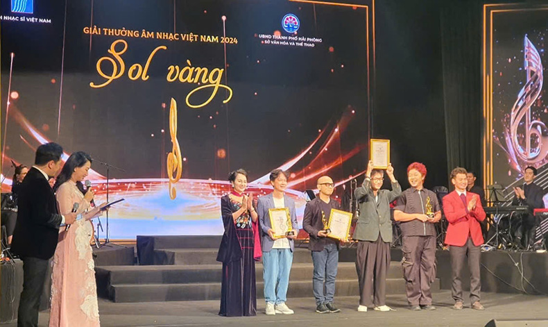 People's Artist Xuan Bac and People's Artist Nhat Thuan presented the Golden Sol award in the 2024 music awards series to 4 authors. Photo: Mai Chi