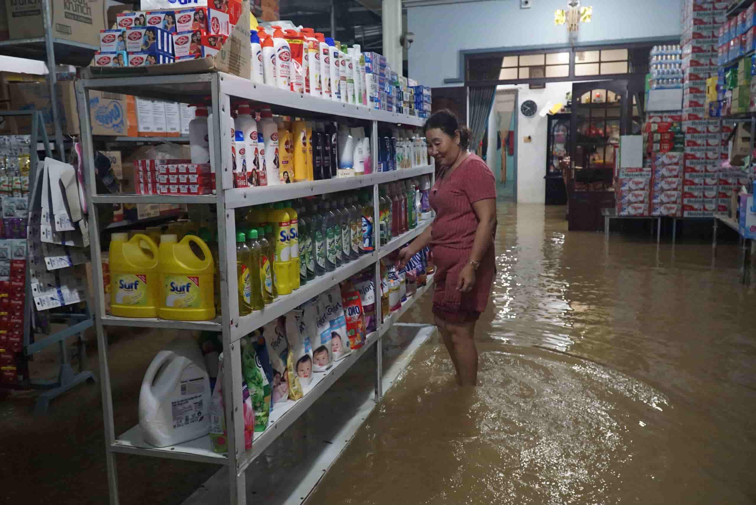 Ba Tran, 53 tuoi, dung mot tam nhom duoc han kin de chan lu nhung nuoc chay manh va co ke ho nen nha van ngap hon 30 cm.  “Lu nam nay len kha nhanh, do dung va hang hoa khong anh huong vi vo chong toi da di doi len cao“, ba Tran noi.