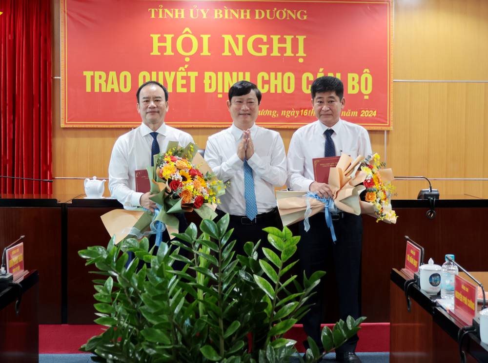 Mr. Vo Van Minh - Chairman of the Provincial People's Committee presented the decision to Mr. To Van Dat (left cover) - Chairman of the People's Committee of Phu Giao district and Mr. Nguyen Phu Cuong (right cover) - Chairman of the People's Committee of Bau Bang district. Photo: Phuong Chi