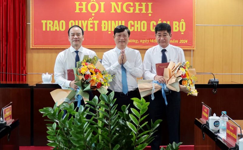 Mr. Vo Van Minh - Chairman of the Provincial People's Committee presented the decision to Mr. To Van Dat (left cover) - Chairman of the People's Committee of Phu Giao district and Mr. Nguyen Phu Cuong (right cover) - Chairman of the People's Committee of Bau Bang district. Photo: Phuong Chi