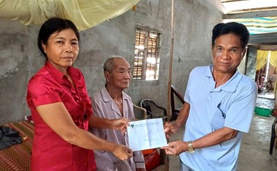Mr. Danh Huong (nearly 100 years old, Khmer ethnic group) was supported and guided by Mr. Lam to complete the procedures to receive the subsidy. Photo: Xuan Nhi