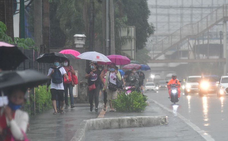 Rain falls on pedestrians in Quezon City, Philippines. Photo: ABS