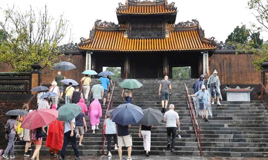 Du khách đội mưa tham qua di tích Huế. Ảnh: Nhật Bình