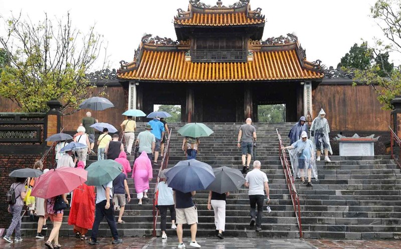 Tourists brave the rain to visit Hue relics. Photo: Nhat Binh