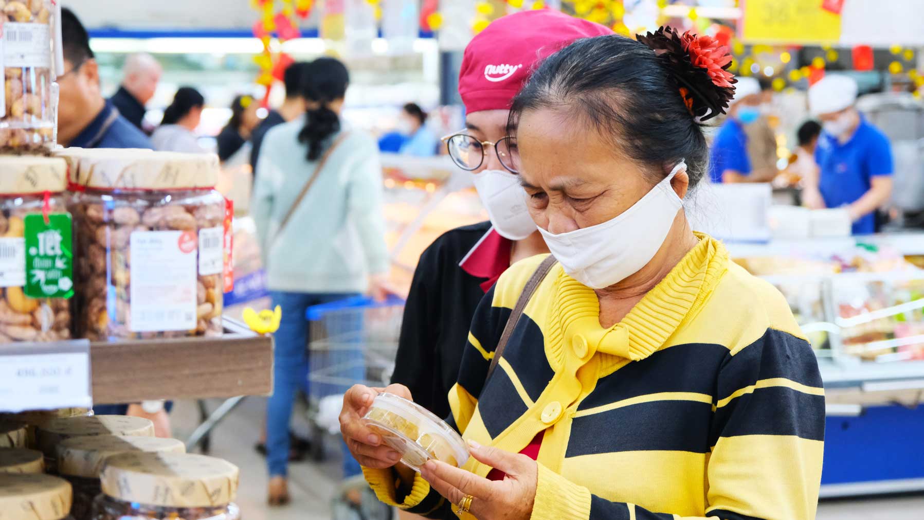 Nguoi dan tham khao gia cac mat hang banh mut Tet. Anh: My Ly