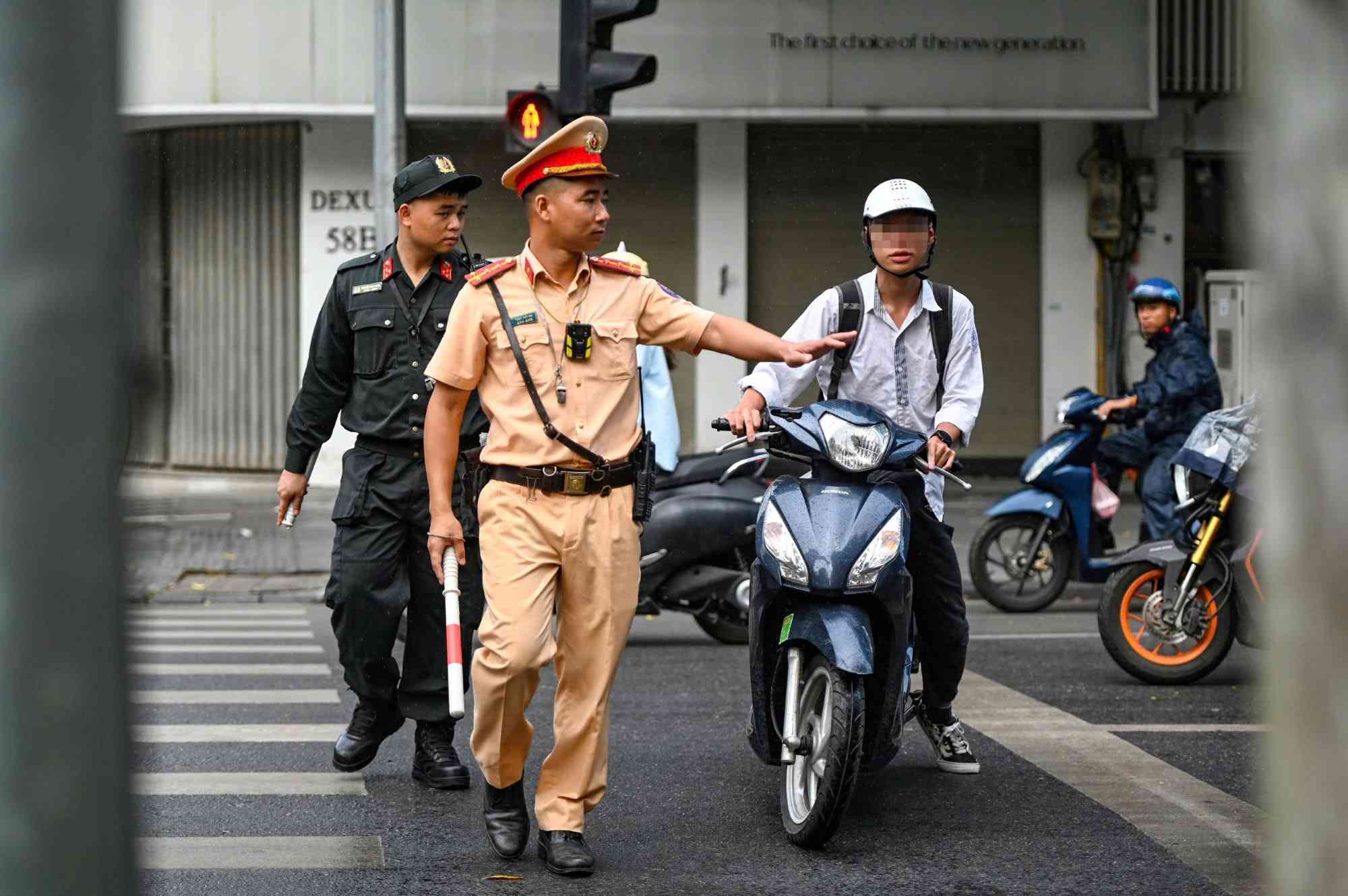 Traffic police handle students violating traffic laws in Hanoi. Photo: To The