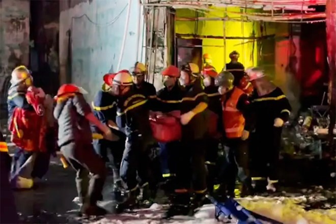 Firefighters rescue people in a house fire that killed 11 people in Hanoi. Photo: The Century