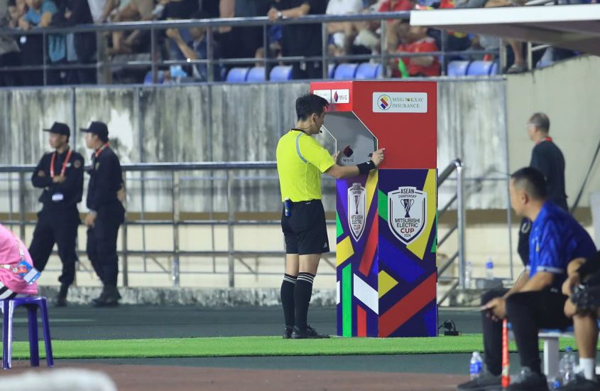 The referee listens to the signal from the VAR room and directly reviews the situation on the VAR screen during the match between Vietnam and Laos. Photo: Minh Dan