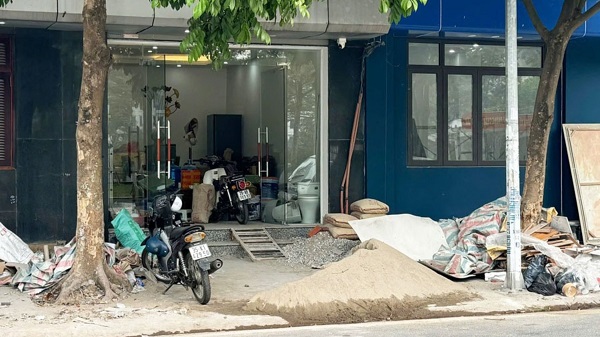 Công trình thi công đổ đất đá, cát sỏi trên vỉa hè gây ô nhiễm môi trường trước cửa nhà số 119 phố Hoàng Như Tiếp (quận Long Biên). Ảnh: Minh Hạnh