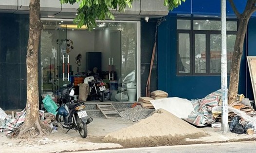 Công trình thi công đổ đất đá, cát sỏi trên vỉa hè gây ô nhiễm môi trường trước cửa nhà số 119 phố Hoàng Như Tiếp (quận Long Biên). Ảnh: Minh Hạnh