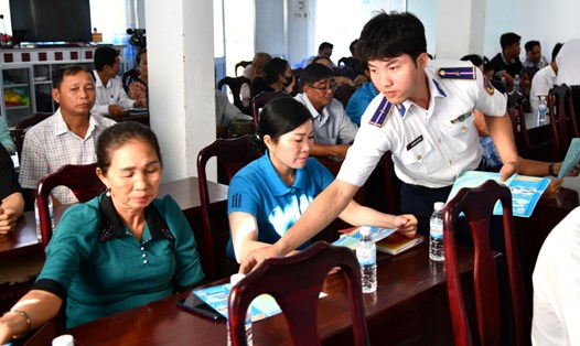 Lực lượng Hải đoàn 42 - Bộ Tư lệnh Vùng Cảnh sát biển 4 phát tờ rơi tuyên truyền cho người dân. Ảnh: Trần Đức