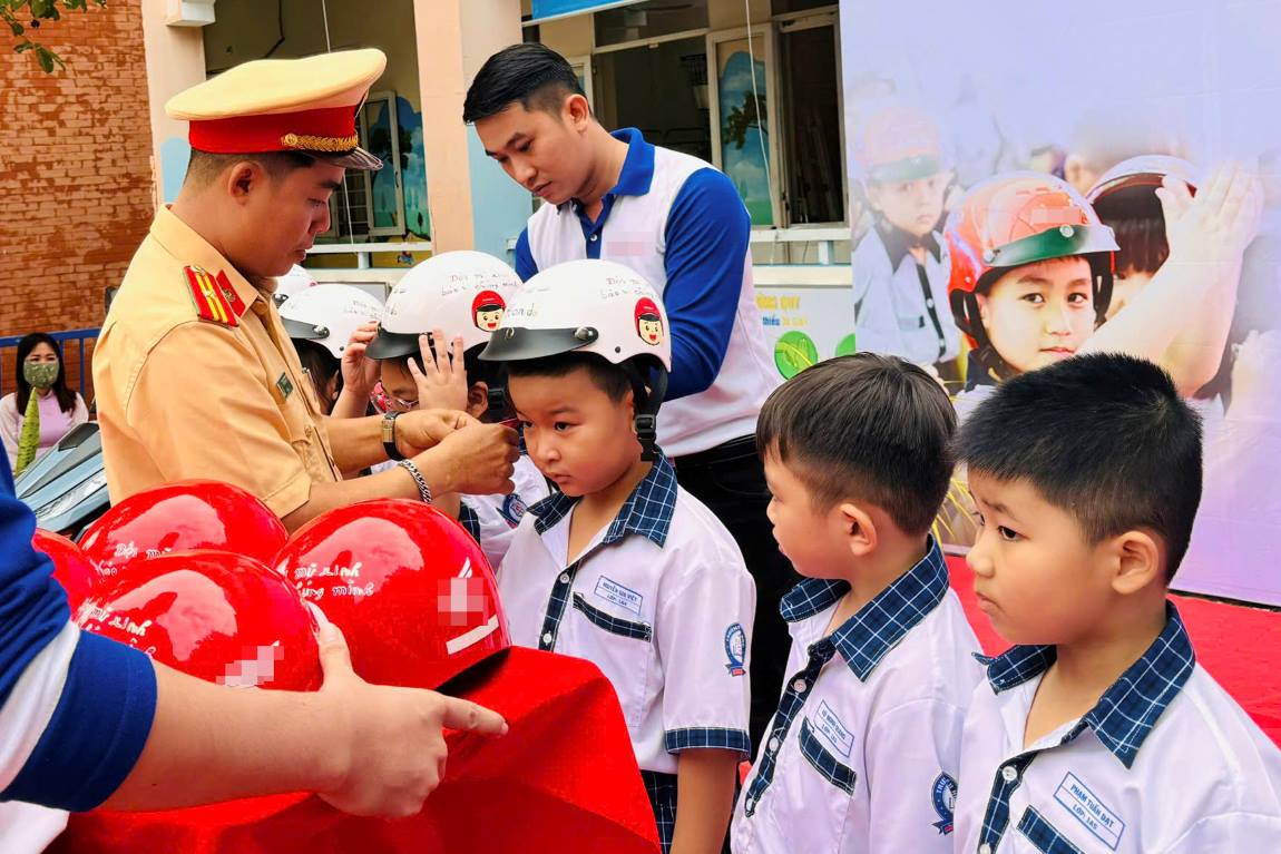 Hoc sinh duoc huong dan doi mu bao hiem. Anh: Ta Quang