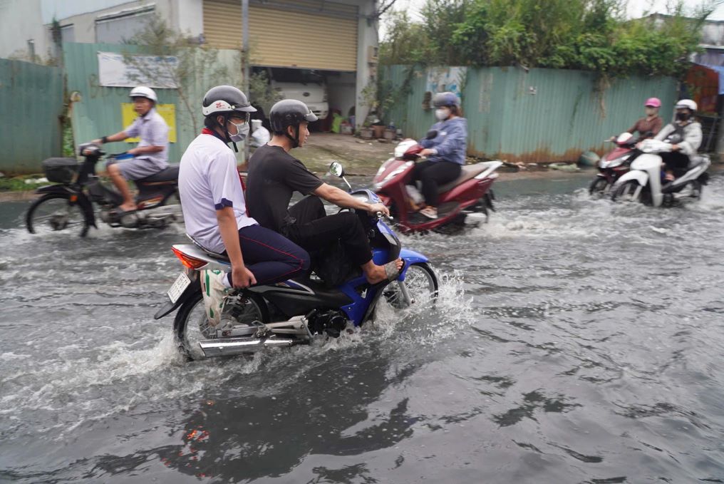 Den khoang 17h, nuoc tren mat duong Le Van Luong ngap tu khoang 20-40cm, khien viec di lai cua nguoi dan gap nhieu kho khan.