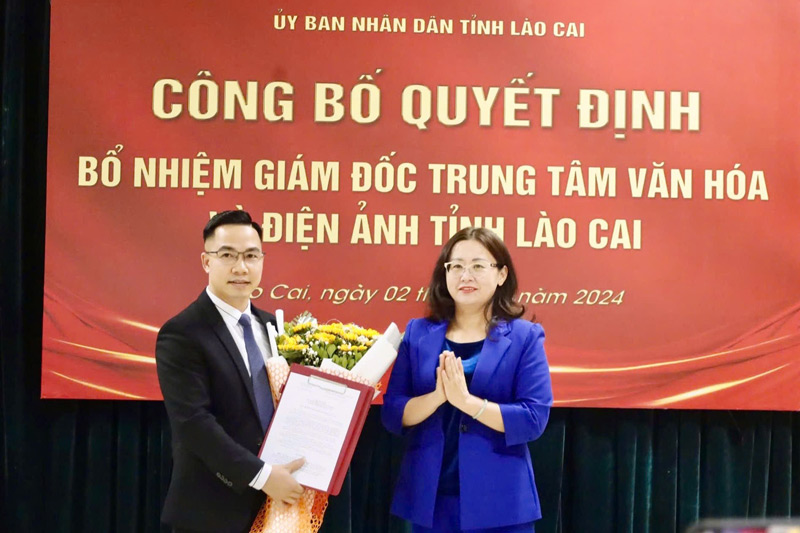 Mr. Vu Dinh Trong received flowers and the appointment decision from Vice Chairman of Lao Cai Provincial People's Committee Giang Thi Dung. Photo: To Dung
