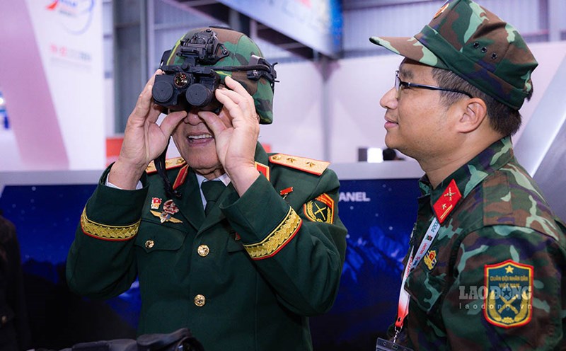 Lieutenant General and pilot Pham Tuan experiences a helmet equipped with multi-channel night vision goggles at a defense exhibition. Photo: Hai Nguyen