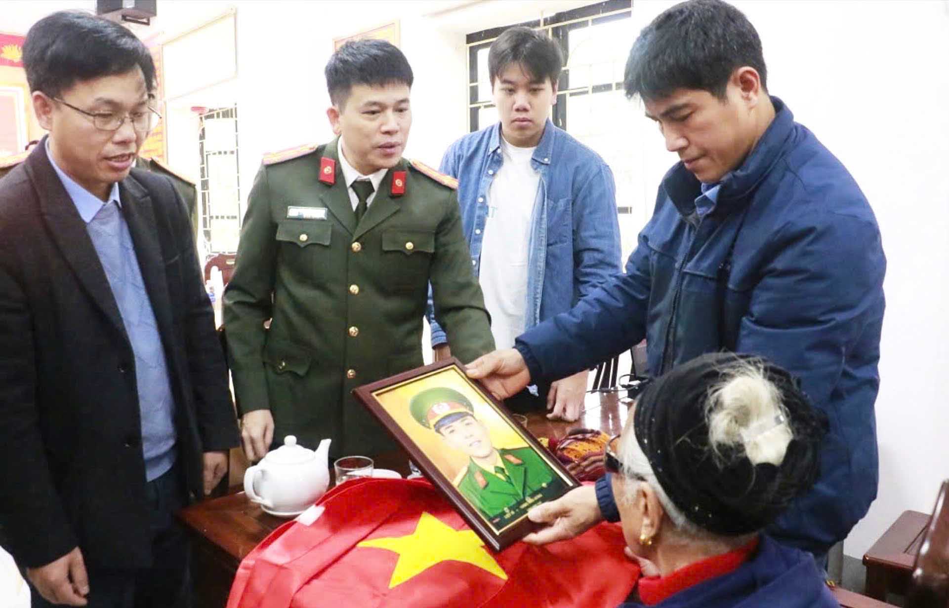 Colonel Tran Hong Quang - Deputy Secretary of the Party Committee, Deputy Director of Nghe An Provincial Police - presented photos of martyrs to relatives. Photo: Nghe An Police