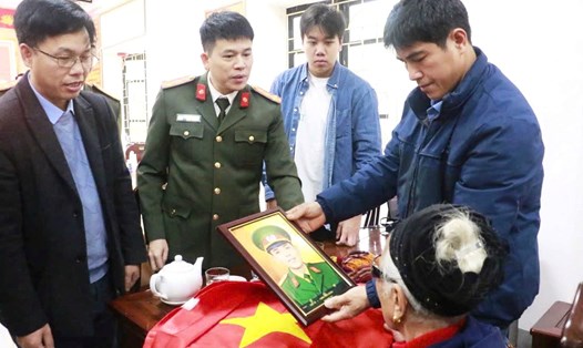 Đại tá Trần Hồng Quang - Phó Bí thư Đảng ủy, Phó Giám đốc Công an tỉnh Nghệ An - trao ảnh liệt sĩ cho thân nhân. Ảnh: Công an Nghệ An