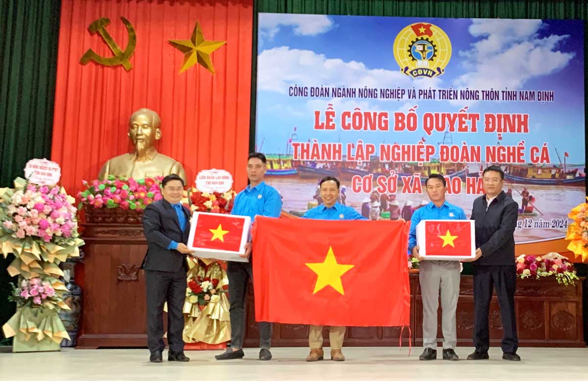 Presenting the national flag to the representative of the Fisheries Union of Giao Hai commune (Giao Thuy district, Nam Dinh province). Photo: Luong Ha