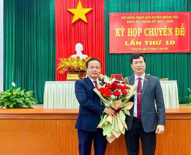 Mr. Tran Hong Tien, Secretary of the District Party Committee, Chairman of the People's Council of Krong Pac district, presented flowers to congratulate Mr. Tran Quoc Vinh, the new Chairman of the District People's Committee. Photo: People's Committee of Krong Pac district