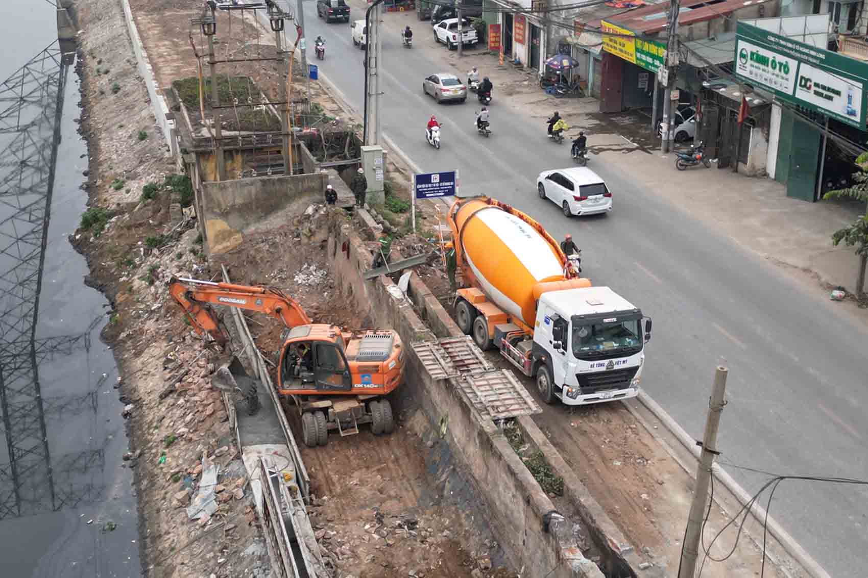 Máy móc thi công hạng mục bờ kè dọc sông Kim Ngưu. Ảnh: Hữu Chánh