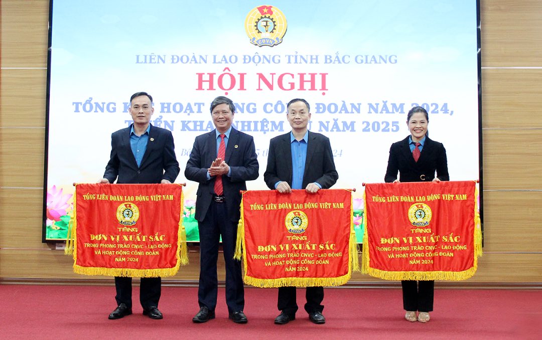 Chairman of the Bac Giang Provincial Federation of Labor Nguyen Van Canh (second from left) presents the Emulation Flag of the Vietnam General Confederation of Labor to collectives with outstanding achievements in 2024. Photo: Quyet Chien