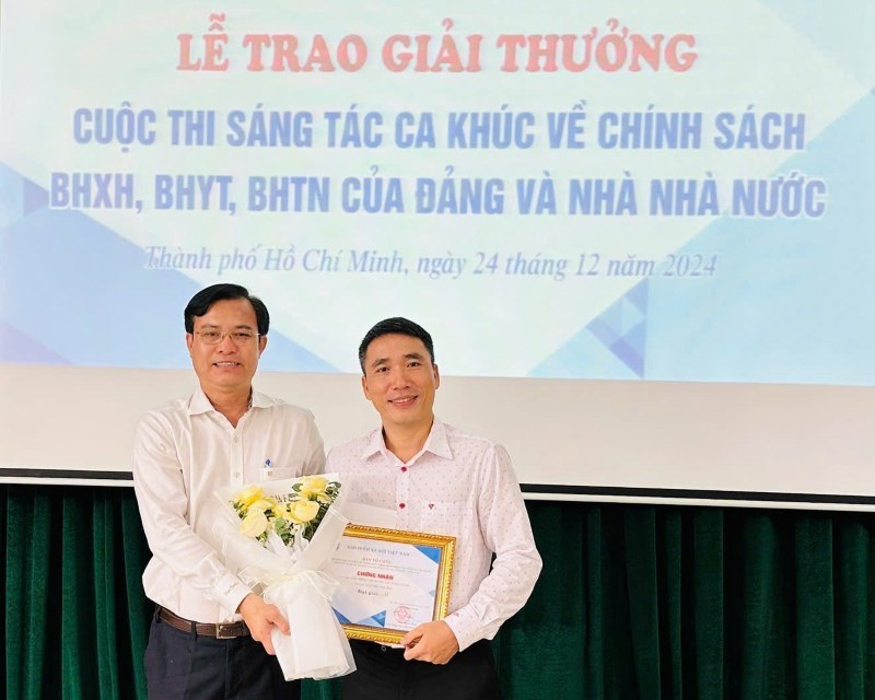 Ong Nguyen Minh Chau - Pho Giam doc BHXH TPHCM (ben trai) - trao giai cho tac gia Nguyen Van Hau. Anh: Duc Long