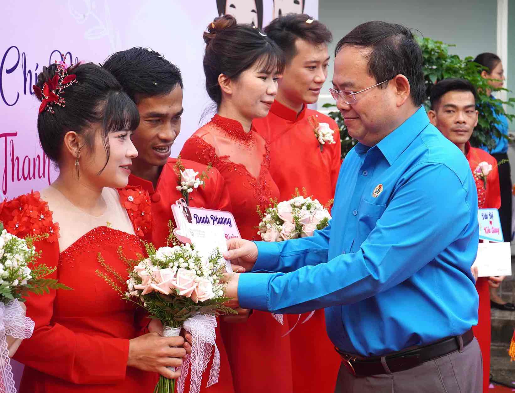 Deputy Secretary of Dong Nai Provincial Party Committee Quan Minh Cuong presents gifts to worker couples at the mass wedding ceremony. Photo: HAC