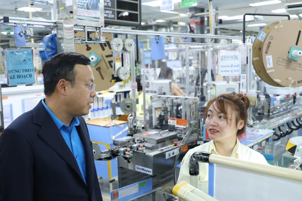 Ms. Quach Thi Huong was talked and asked by Mr. Pham Quang Thanh - Member of the Presidium of the Vietnam General Confederation of Labor, Chairman of the Hanoi City Confederation of Labor right at the production line. Photo: Manh Quan