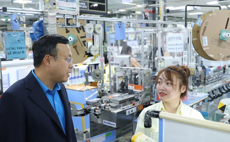 Ms. Quach Thi Huong was talked and asked by Mr. Pham Quang Thanh - Member of the Presidium of the Vietnam General Confederation of Labor, Chairman of the Hanoi City Confederation of Labor right at the production line. Photo: Manh Quan