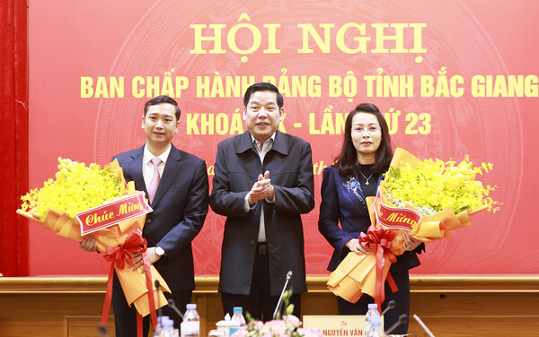 Secretary of Bac Giang Provincial Party Committee Nguyen Van Gau presents flowers to congratulate the two new Deputy Secretaries of the Provincial Party Committee. Photo: Bac Giang Portal