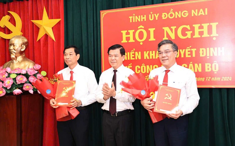 Secretary of Dong Nai Provincial Party Committee Nguyen Hong Linh presents the decision to Mr. Duong Minh Dung (right) and Mr. Vo Van Phi (left) at Long Thanh District Party Committee. Photo: HAC